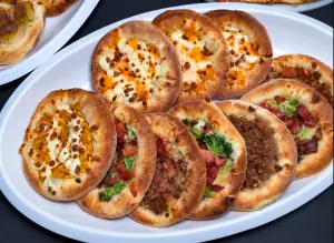 Travessa de esfihas abertas de frango com cheddar, carne e calabresa com brócolis