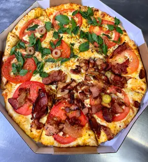 Pizza meio marguerita com tomate e manjericão, meio bacon, na caixa